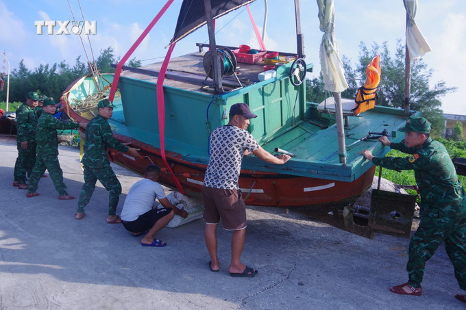 Lực lượng chức năng hỗ trợ ngư dân di chuyển tàu thuyền lên bờ tránh bão. Ảnh: TTXVN phát vna_potal_huyen_dao_tien_tieu_bach_long_vi_hai_phong_khan_truong_phong_chong_bao_so_3__7574252.jpg