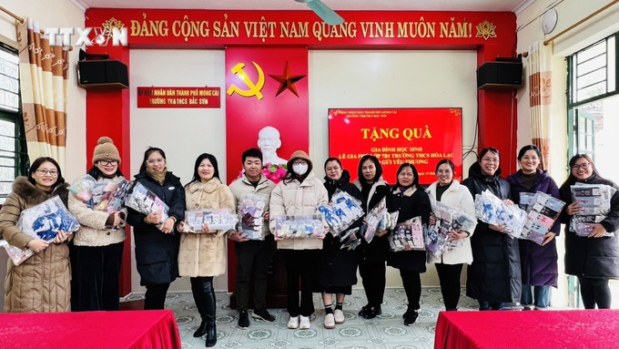 Đại diện giáo viên nhà trường tiếp nhận quà của em Phú. Ảnh: TTXVN phát vna_potal_quang_ninh_mot_hoc_sinh_dung_tien_tiet_kiem_mua_700_doi_tat_tang_cac_ban_vung_bien_gioi_7198214.jpg