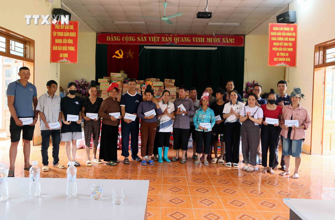 Các nhà hảo tâm trao tiền hỗ trợ cho nhân dân xã Tông Cọ, huyện Thuận Châu, tỉnh Sơn La. Ảnh: Quang Quyết - TTXVN vna_potal_son_la_ho_tro_nhan_dan_vung_ngap_lut_xa_tong_co_vuot_qua_kho_khan__7511738.jpg