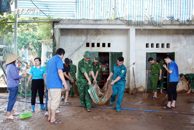 Lực lượng Công an, bộ đội và đoàn viên thanh niên hỗ trợ người dân Sơn La khắc phục hậu quả sau mưa lũ. Ảnh: Quang Quyết – TTXVN vna_potal_son_la_ung_pho_khan_cap_voi_nguy_co_mua_lon_tiep_tuc_tren_dien_rong_7505854.jpg