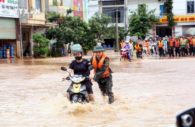 Bộ đội hỗ trợ người dân di chuyển qua khu vực bị ngập lụt tại thành phố Sơn La. Ảnh: Quang Quyết – TTXVN vna_potal_son_la_ung_pho_khan_cap_voi_nguy_co_mua_lon_tiep_tuc_tren_dien_rong_7505857.jpg