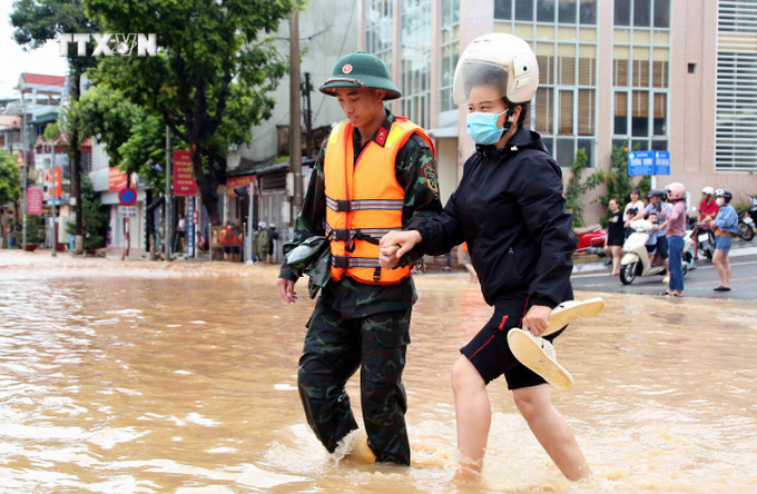 Bộ đội hỗ trợ người dân di chuyển qua khu vực bị ngập lụt tại thành phố Sơn La. Ảnh: Quang Quyết – TTXVN vna_potal_son_la_ung_pho_khan_cap_voi_nguy_co_mua_lon_tiep_tuc_tren_dien_rong_7505865.jpg