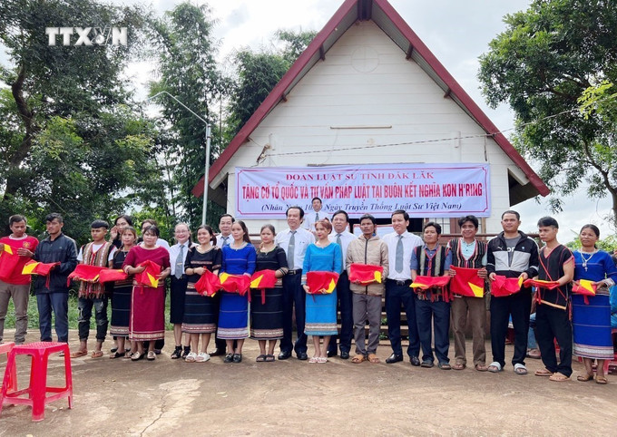 Đoàn Luật sư tỉnh Đắk Lắk tặng cờ Tổ quốc và tư vấn pháp luật tại buôn kết nghĩa Hring, xã Ea H’đing, huyện Cư M’gar. Ảnh: TTXVN phát vna_potal_dak_lak_20_nam_ket_nghia_buon_lang_tham_tinh_doan_ket_7574797.jpg