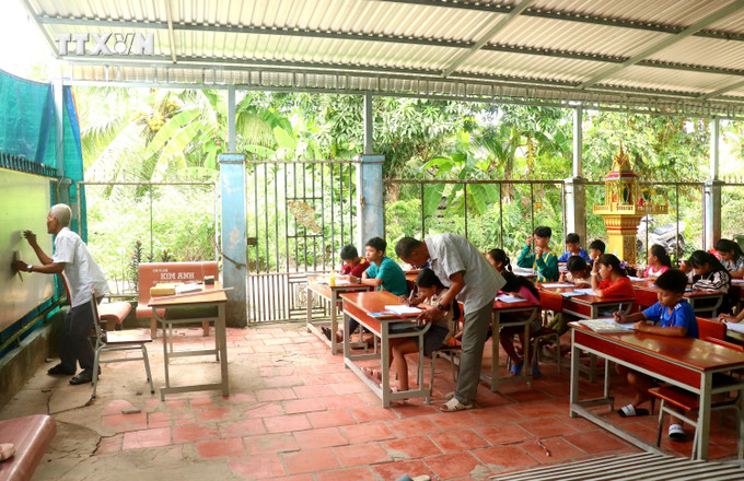 Lớp dạy chữ Khmer ở ấp Thới Trường 2, xã Thới Xuân do ông Thạch Hoàng Anh và Thạch Sung giảng dạy. Ảnh: Thu Hiền - TTXVN vna_potal_van_hoa_soi_duong_truyen_giu_chu_khmer_cho_the_he_sau_7484522.jpg