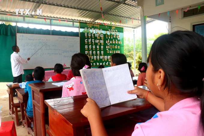 Học sinh học đọc chữ Khmer ở lớp dạy chữ Khmer ấp Thới Trường 1, xã Thới Xuân. Ảnh: Thu Hiền - TTXVN vna_potal_van_hoa_soi_duong_truyen_giu_chu_khmer_cho_the_he_sau_7484524.jpg