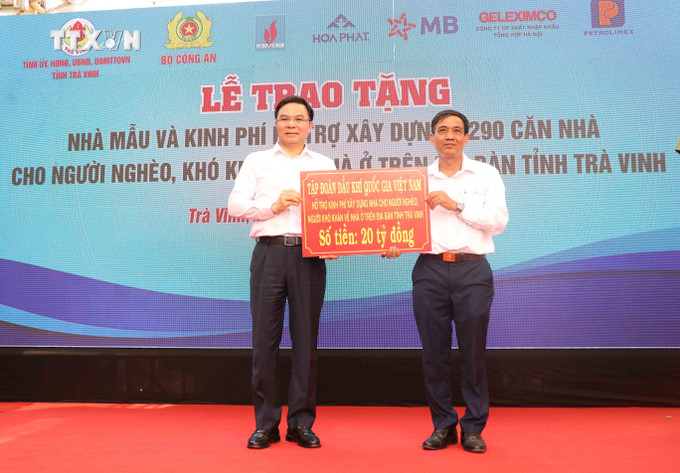 Phó Chủ tịch Ủy ban MTTQ Việt Nam tỉnh Trà Vinh Kiên Banh (bên phải) nhận nguồn hỗ trợ. Ảnh: Thanh Hòa-TTXVN vna_potal_bo_cong_an_ho_tro_xay_dung_1290_can_nha_cho_ho_ngheo_o_tra_vinh_7319365.jpg