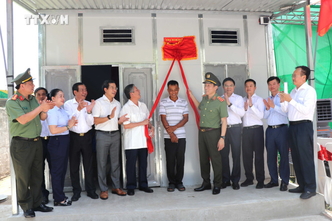 Nghi lễ kéo băng trao tặng nhà mẫu. Ảnh: Thanh Hòa-TTXVN vna_potal_bo_cong_an_ho_tro_xay_dung_1290_can_nha_cho_ho_ngheo_o_tra_vinh_7319355.jpg