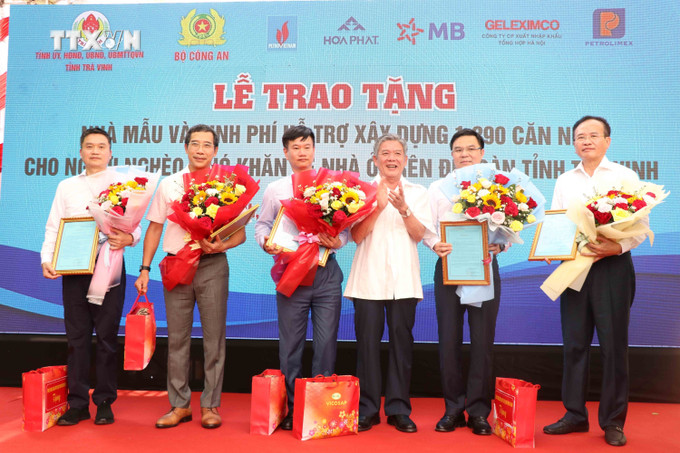 Bí thư Tỉnh ủy Trà Vinh Ngô Chí Cường tặng hoa các đơn vị tài trợ. Ảnh: Thanh Hòa- TTXVN vna_potal_bo_cong_an_ho_tro_xay_dung_1290_can_nha_cho_ho_ngheo_o_tra_vinh_7319370.jpg