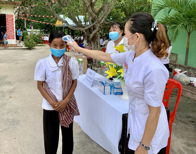 Đồng bào dân tộc Khmer huyện biên giới Tri Tôn, Tịnh Biên cùng với hơn 1,63 triệu cử tri toàn tỉnh An Giang đã thực hiện quyền và nghĩa bỏ phiếu bầu cử. Trong ảnh: Cử tri trước khi vào phòng bỏ phiếu đều được do thân nhiệt phòng, chống dịch bệnh. Ảnh: Thanh Sang - TTXVN. Cử tri đồng bào dân tộc, tôn giáo, vùng sâu, vùng xa, khu vực biên giới nô nức tham gia bầu cử ảnh 5