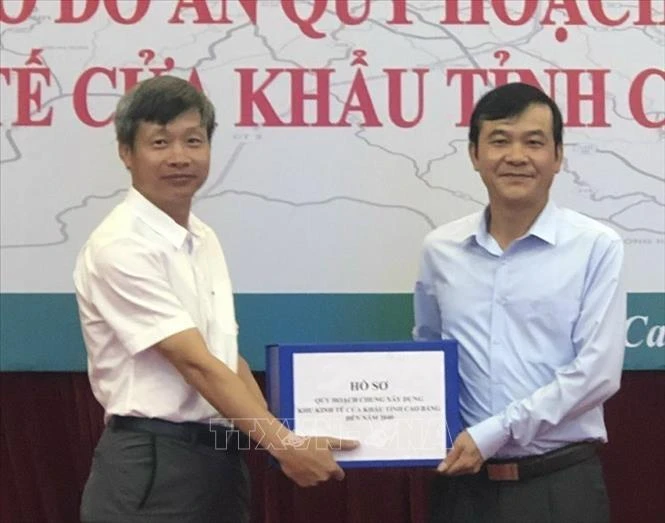 Đại diện của Vụ Quy hoạch kiến trúc, Bộ Xây dựng trao Hồ sơ quy hoạch chung xây dựng Khu kinh tế cửa khẩu tỉnh Cao Bằng cho đại diện lãnh đạo tỉnh Cao Bằng. Ảnh: Quốc Đạt - TTXVN