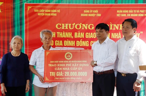 Lãnh đạo huyện Đoan Hùng trao tượng trưng số tiền hỗ trợ xây dựng căn nhà cấp ủy và tặng quà cho gia đình đảng viên. Ảnh: Trung Kiên - TTXVN
