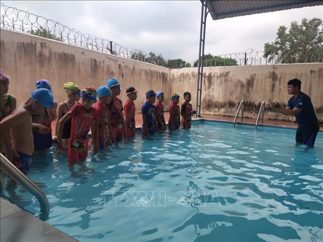 Các em học sinh của trường Tiểu học Ngô Thì Nhậm, xã Ia Chim, thành phố Kon Tum khởi động trước khi xuống nước tập bơi. Ảnh: TTXVN
