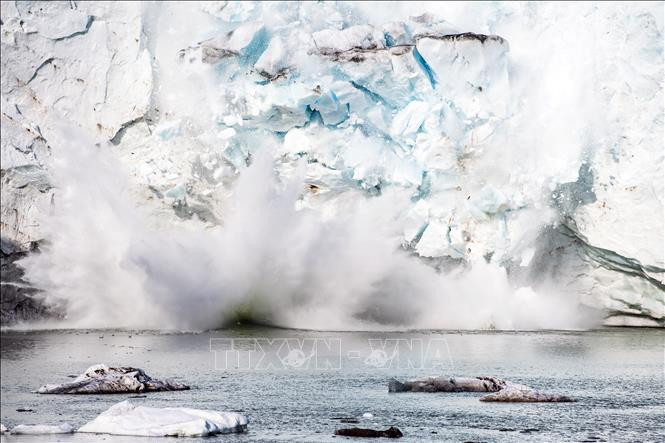 Băng tách ra từ một núi băng trên sông băng Apusiajik, gần Kulusuk, phía Đông Nam đảo Greenland. Ảnh: AFP/TTXVN