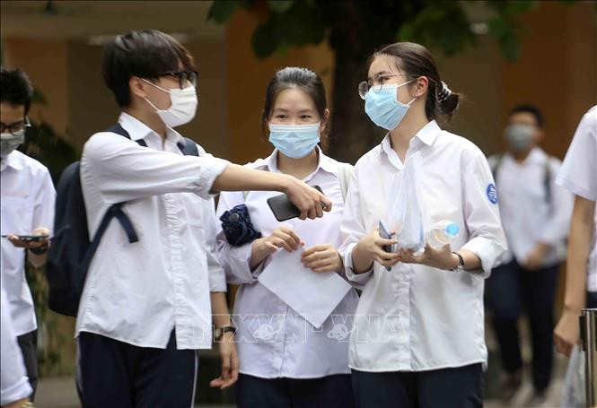Các thí sinh tại điểm thi trường THCS Ngô Sĩ Liên trao đổi bài làm của mình sau khi hoàn thành bài thi. Ảnh: Tuấn Đức - TTXVN