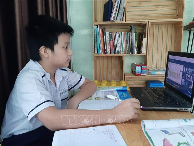 Học sinh Trung học cơ sở tại Long An học trực tuyến trước khi được tiêm vaccine phòng dịch COVID-19. Ảnh: Đức Hạnh - TTXVN