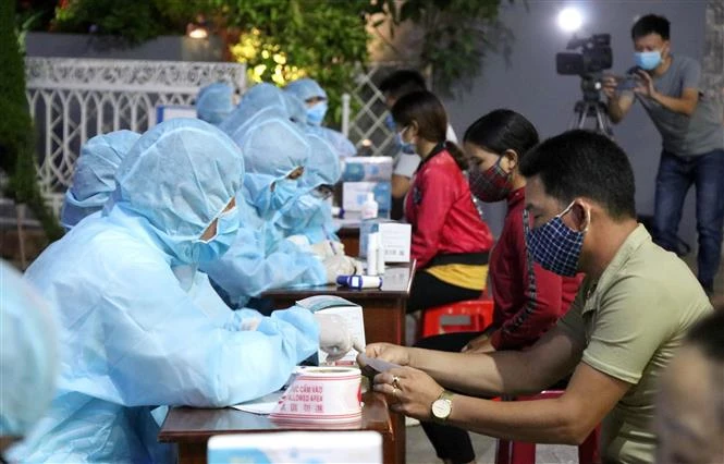 Lực lượng chức năng tổ chức lấy mẫu xét nghiệm sàng lọc SARS-CoV-2 cho tiểu thương chợ đêm Pleiku, Gia Lai. Ảnh: Quang Thái - TTXVN 