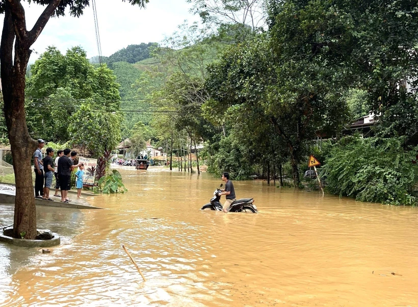 Một người dân cố đi xe qua chỗ ngập nhưng đã phải quay lại. Ảnh: Tuấn Anh - TTXVN