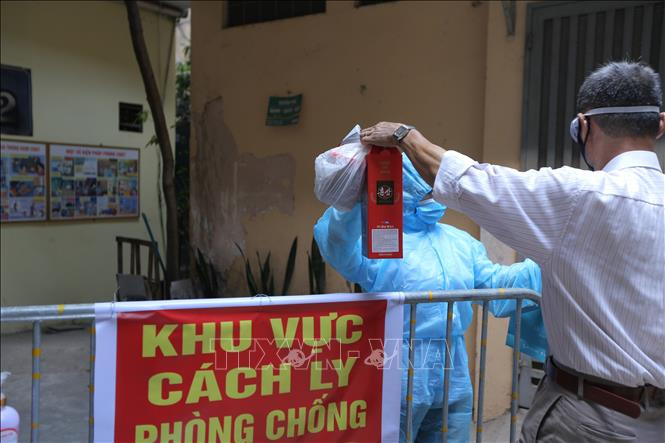 Đồ tiếp tế của người dân được lực lượng chức năng đưa vào khu vực cách ly y tế. Ảnh: Hoàng Hiếu - TTXVN