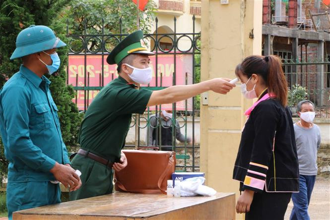 Lực lượng biên phòng Lai Châu phối hợp với lực lượng dân quân địa phương thực hiện nghiêm các biện pháp phòng chống dịch khi đi tuyên truyền bà con nhân dân. Ảnh: Đinh Thùy-TTXVN 
