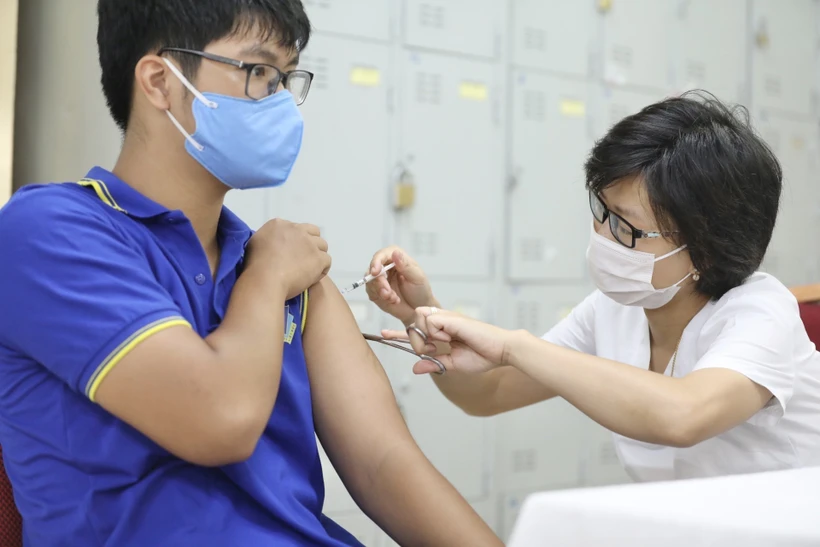 Nhân viên y tế tiêm vaccine phòng COVID-19 cho nhóm tuổi từ 12-17 tại điểm tiêm trường THPT Việt Đức (Hoàn Kiếm, Hà Nội). Ảnh: Minh Quyết - TTXVN