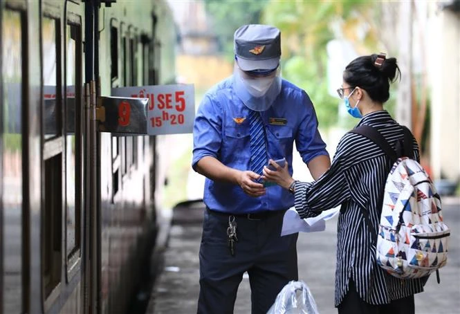 Hành khách xuất trình Khai báo y tế trực tuyến trước khi lên tàu. Ảnh: Thành Đạt - TTXVN 