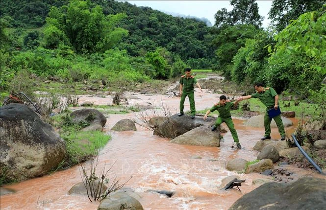 Đường xuống bản khó khăn không cản nổi bước chân của lực lượng công an xã Sín Thầu (Mường Nhé). Ảnh: Nhật Anh - TTXVN