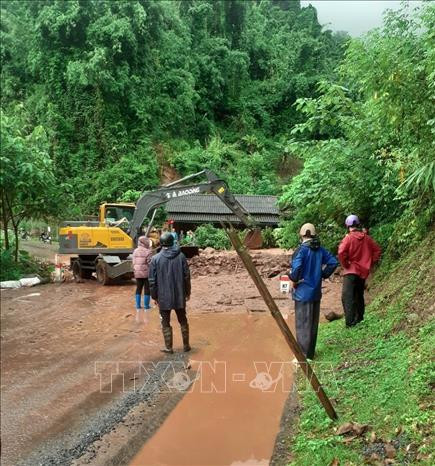 Lực lượng nhân công và xe chuyên dụng giải phóng hiện trường các điểm sạt lở trên tuyến quốc lộ 4H. Ảnh: TTXVN phát