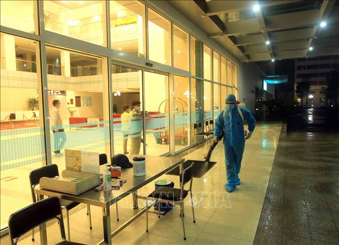 Nhân viên y tế phun thuốc khử trùng tiêu độc ngay trong đêm tại Bệnh viện quốc tế Vinmec Hải Phòng. Ảnh: An Đăng - TTXVN