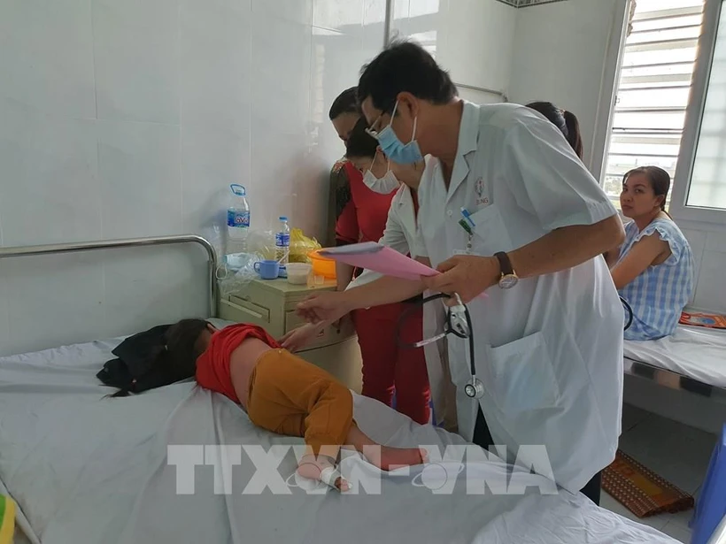 Bác sĩ Chuyên khoa II Huỳnh Hùng Dũng – Trưởng khoa Truyền nhiễm, Bệnh viện Nhi đồng thành phố Cần Thơ thăm khám cho một bệnh nhi bị bệnh tay chân miệng. Ảnh: Ánh Tuyết – TTXVN