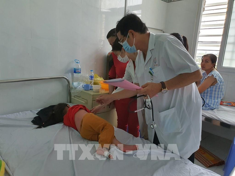 Bác sĩ Chuyên khoa II Huỳnh Hùng Dũng – Trưởng khoa Truyền nhiễm, Bệnh viện Nhi đồng thành phố Cần Thơ thăm khám cho một bệnh nhi bị bệnh tay chân miệng. Ảnh: Ánh Tuyết – TTXVN