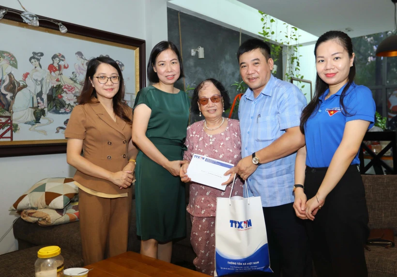Tổng Giám đốc TTXVN Vũ Việt Trang thăm hỏi, tặng quà bà Phương Thị Bích Ngân, vợ liệt sĩ, nhà báo Thẩm Đức Hòa (huyện Gia Lâm, Hà Nội). Ảnh: Hoàng Hiếu - TTXVN