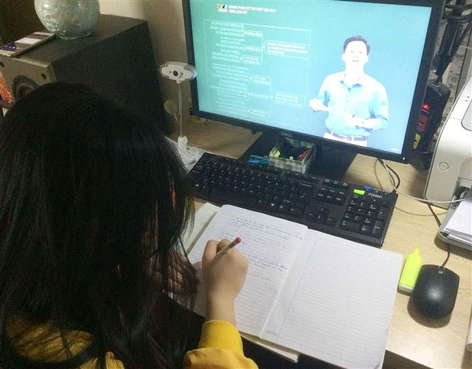 Học sinh lớp 12 trường THPT Quang Trung (quận Đống Đa) học trực tuyến. Ảnh: TTXVN phát 