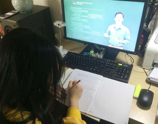 Học sinh lớp 12 trường THPT Quang Trung (quận Đống Đa) học trực tuyến. Ảnh: TTXVN phát 
