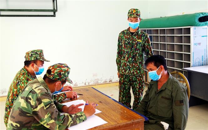 Cán bộ, chiến sĩ Đồn Biên phòng Cửa khẩu Chi Ma lấy lời khai đối tượng đưa người nhập cảnh trái phép. Ảnh: Thái Thuần-TTXVN