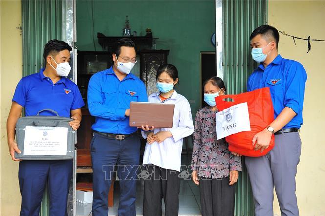 Phó Bí thư Thành đoàn Hà Nội Trần Quang Hưng trao tặng cho cháu Trần Thị Thanh Chúc có hoàn cảnh khó khăn tại huyện Thường Tín máy tính và túi an sinh.Ảnh: Minh Đức – TTXVN
