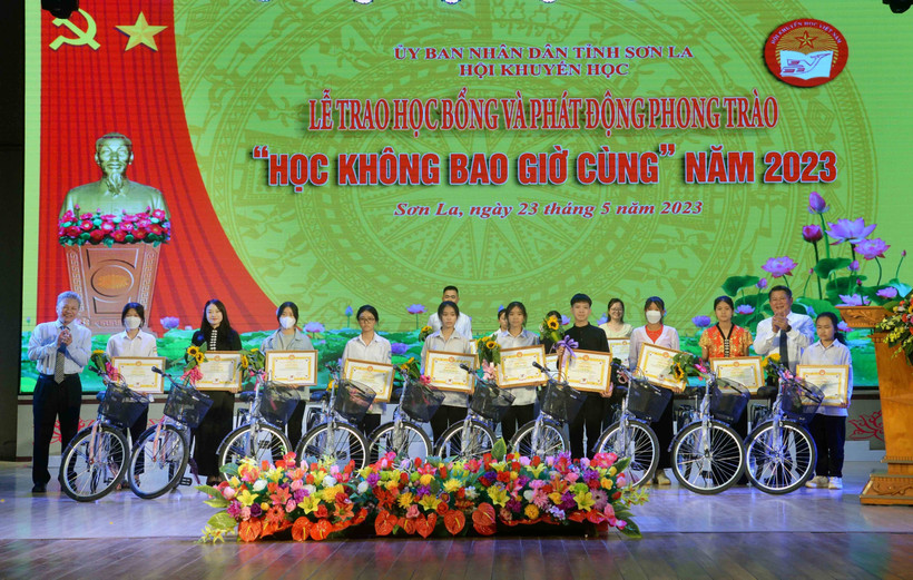 Ban Tổ chức trao Giấy khen của Hội Khuyến học tỉnh Sơn La và xe đạp cho các em học sinh. Ảnh: Quang Quyết - TTXVN