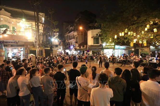 Biểu diễn văn nghệ tại ngã tư phố Đinh Liệt và Gia Ngư thu hút đông đảo người dân và khách du lịch. Ảnh: Hoàng Hiếu - TTXVN