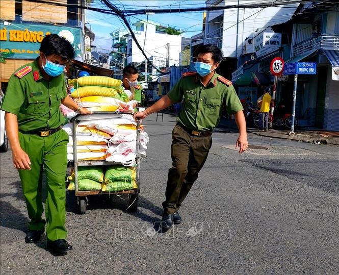  Lực lượng Công an phường An Cư vận chuyển quà đến trao tặng người dân gặp khó khăn do dịch COVID-19. Ảnh: Thu Hiền - TTXVN
