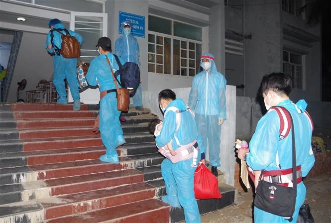 Công dân được các nhân viên y tế hướng dẫn vào khu cách ly. Ảnh: Chanh Đa-TTXVN 