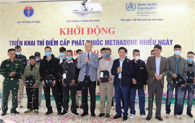 Trao túi đựng thuốc Methadone cho các bệnh nhân được cấp thuốc mang về nhà. Ảnh: Đinh Thùy-TTXVN 