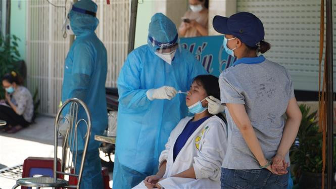 Lực lượng y tế tiến hành lấy mẫu xét nghiệm người dân nơi bị phong tỏa. Ảnh: TTXVN phát 