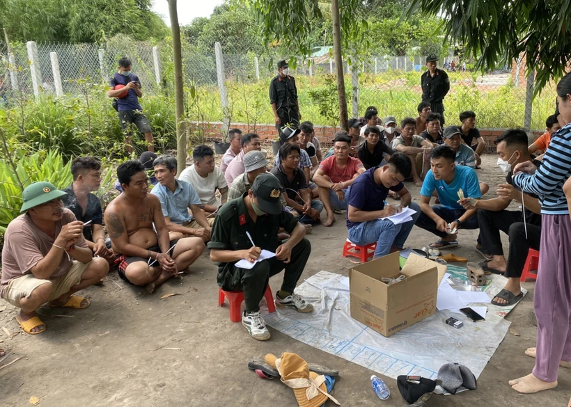 Các đối tượng đánh bạc bị bắt giữ tại hiện trường. Ảnh: TTXVN phát