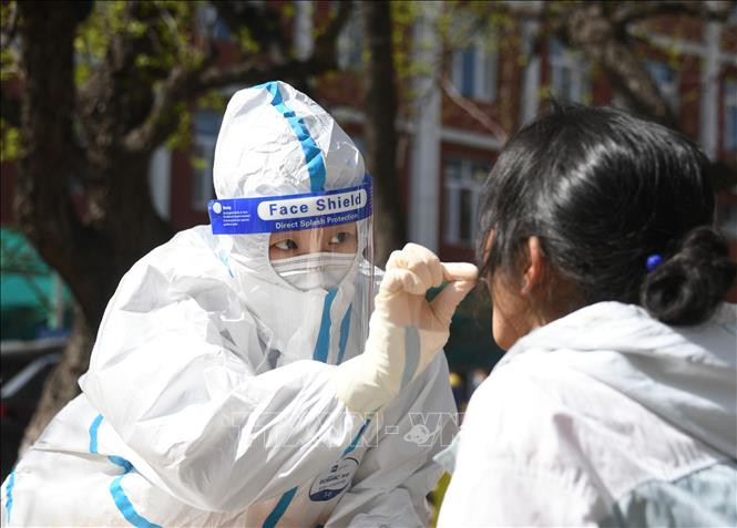 Nhân viên y tế lấy mẫu xét nghiệm COVID-19 cho người dân tại Bắc Kinh, Trung Quốc ngày 26/4/2022. Ảnh: THX/TTXVN