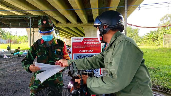 Kiểm tra giấy tờ của người dân về Cần Thơ tại chốt kiểm soát số 4. Ảnh: Thu Hiền - TTXVN