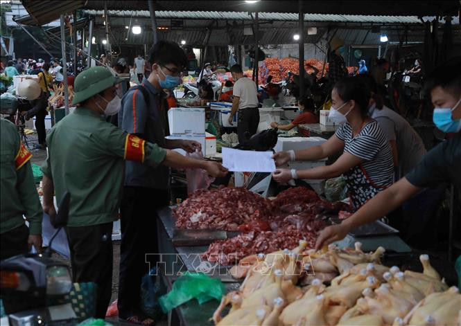 Ban Quản lý chợ thường xuyên tổ chức tuyên truyền, nhắc nhở người dân thực hiện nghiêm các quy định về phòng chống dịch. Ảnh: Vũ Sinh - TTXVN