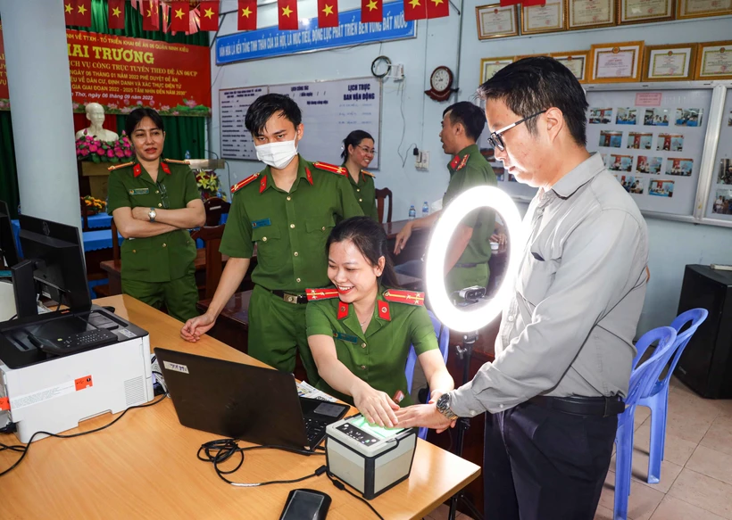 Cán bộ Công an phường Tân An, quận Ninh Kiều hướng dẫn người dân thực hiện đăng ký tài khoản định danh điện tử mức độ 2. Ảnh: TTXVN phát