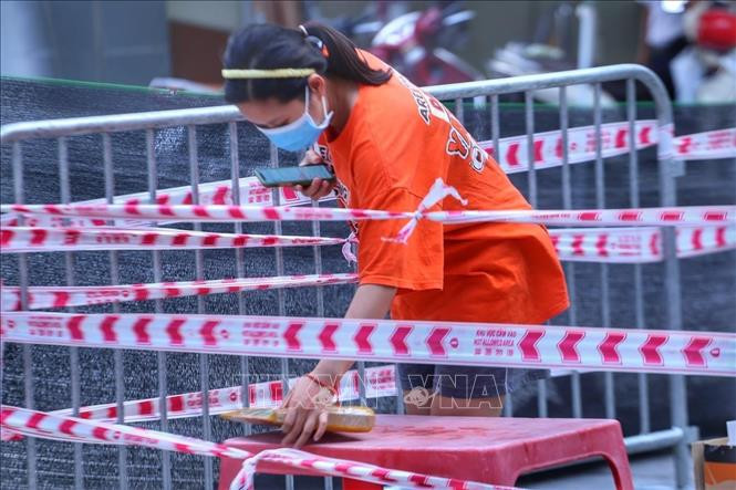 Người dân tại chung cư 210B Lê Trọng Tấn, phường Khương Mai (quận Thanh Xuân) nhận nhu yếu phẩm. Ảnh: Tuấn Đức - TTXVN