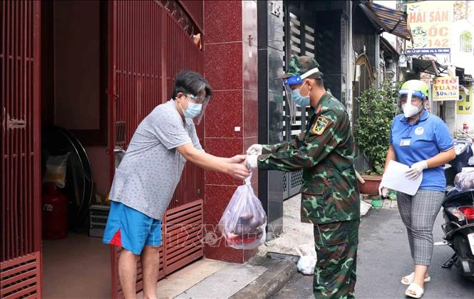Cán bộ, chiên sỹ Sư đoàn 309 vận chuyển quà tặng nhu yếu phẩm sinh hoạt đến cho người dân tại phường 6, quận Tân Bình. Ảnh: Xuân Khu-TTXVN