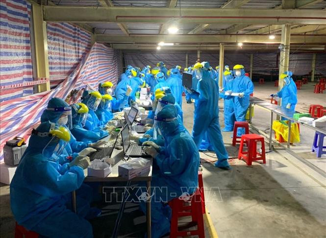 Lực lượng sinh viên Trường Đại học Y dược Cần Thơ hỗ trợ tỉnh Vĩnh Long xét nghiệm test nhanh cho công nhân Khu công nghiệp Hòa Phú.Ảnh: Lê Thúy Hằng - TTXVN