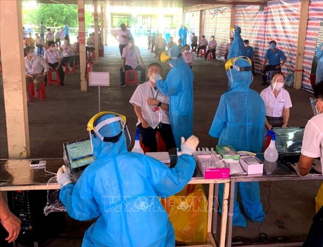 Lực lượng sinh viên Trường Đại học Y dược Cần Thơ hỗ trợ tỉnh Vĩnh Long xét nghiệm test nhanh cho công nhân Khu công nghiệp Hòa Phú. Ảnh: Lê Thúy Hằng - TTXVN